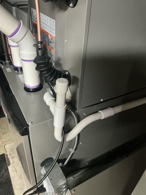 Responded to service call for missing condensation pump from humidifier system. Upon inspection of basement-located HVAC air handler unit, confirmed that condensate pump assembly was not present at equipment. Documented existing installation showing air handler with standard condensate drain piping configuration using white PVC with proper joints and elbows, but lacking dedicated humidifier condensate pump component. Photographed current system setup including visible drainage lines, electrical connections, and equipment placement for warranty documentation purposes.