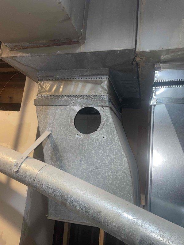 Conducted on-site evaluation for complete air conditioning system replacement at residential property with natural gas furnace located in basement. Assessed existing ductwork configuration including galvanized metal plenum with trapezoidal junction box and cylindrical supply ducts, noting standard operational wear and dust accumulation but no structural deficiencies requiring immediate remediation. Evaluated exterior installation location along side yard utility area adjacent to electrical meter and prepared comprehensive replacement estimate for new AC system compatible with existing natural gas heating infrastructure.