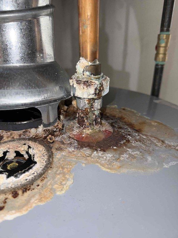 # Gold Furnace Inspection Summary

Completed comprehensive gold-level furnace inspection on forced-air heating system located in basement. Performed thorough examination of all internal components including gas valve, ignition system, blower motor assembly, electrical control board, and flame sensors. Identified significant corrosion on metal fitting connection with extensive rust deposits and material degradation, indicating prolonged moisture exposure. Observed water damage and staining on surrounding surfaces near corroded connection point. Documented condition of all major components through photographic inspection. System components including blue flame sensors, gas valve with proper wiring connections, blower motor assembly, and expansion tank were visually assessed for operational integrity.