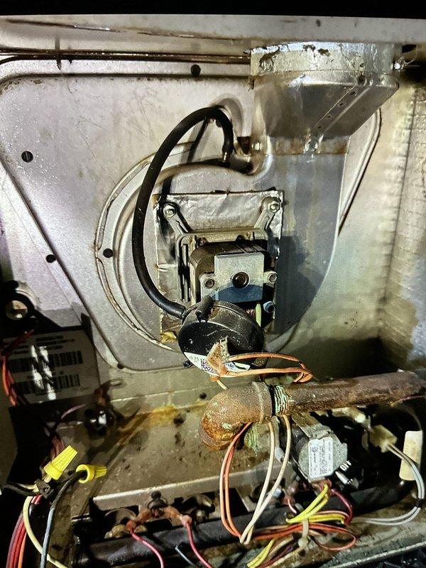 Performed furnace inspection and documented existing equipment condition. Observed significant corrosion on gas supply piping and general wear on internal components including gas valve assembly, electrical connections, and wiring harnesses. Photographed corroded horizontal gas line, control wiring, and mechanical components showing age-related deterioration for customer records and future service reference.