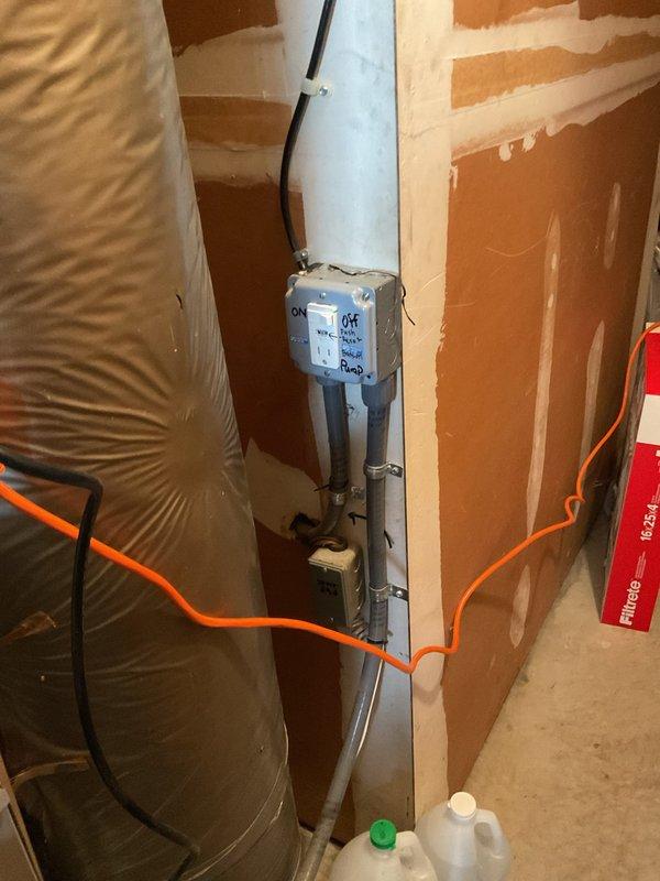 Responded to service call for water leaking from underneath 13+ year old furnace located in garage. Upon inspection, found condensate pump system previously addressed but issue persisting. Evaluated condensate drainage system including PVC piping, pump control box, and discharge lines. Documented existing pump installation and electrical connections for further assessment. Advised that despite previous repair attempt, condensate removal system requires additional troubleshooting to resolve ongoing water leak issue.