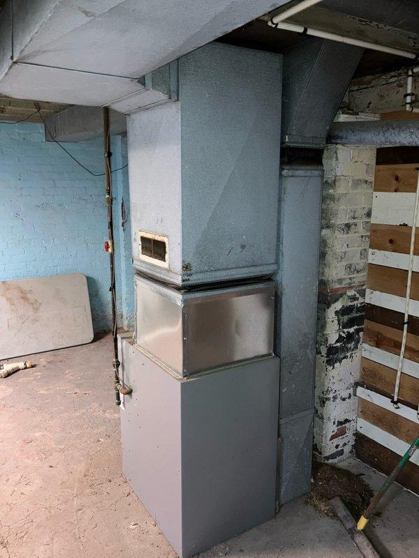 Responded to service call for non-operational hot water heater and furnace diagnostic evaluation in basement mechanical room. Performed comprehensive assessment of existing HVAC system including gray metal furnace unit with exposed internal components and white air handler assembly. Inspected ductwork connections, blower motor assembly, and ventilation system throughout basement area. Evaluated condition of copper piping, electrical connections, and overall system infrastructure. Documented equipment age and operational status through visual inspection with access panel removal. Assessed water heater functionality and provided recommendations for repair versus replacement options for both heating units based on current equipment condition and performance capabilities.