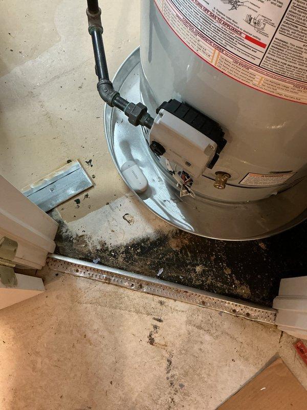 Installed 50-gallon standard capacity tanked water heater in residential utility closet with proper venting and plumbing connections. Unit was positioned on white plastic drain pan with alarm system for leak detection and safety compliance. Reconnected hot and cold water supply lines using copper piping, installed temperature and pressure relief valve assembly, and secured venting system with metallic elbow configuration for proper exhaust. All connections were tested for leaks and proper operation upon completion of installation.