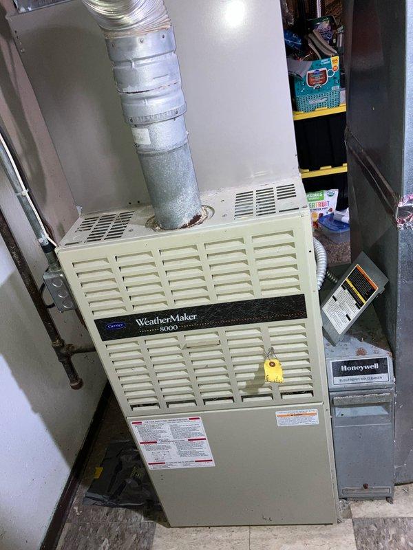Conducted site assessment for replacement of 33-year-old Carrier WeatherMaker 8000 furnace located in basement. Documented existing system configuration including horizontal vent connections, flexible ductwork routing to ceiling plenum, and adjacent Honeywell air filtration unit. Evaluated current mechanical room layout, copper piping infrastructure, electrical connections, and existing supply line conditions with brass fittings showing age-related corrosion. Provided comprehensive replacement estimate addressing complete furnace system upgrade requirements.