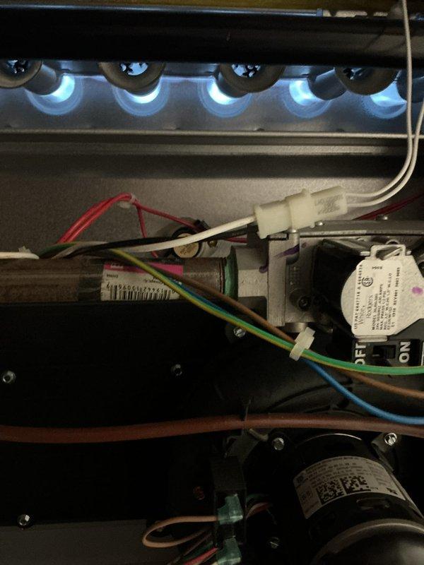 Completed comprehensive Gold-level furnace inspection on residential forced-air heating system located in basement. Unit is less than 10 years old and operational at time of service. Performed thorough visual examination of burner assembly, confirming proper ignition sequence with uniform blue flame pattern across all five burner ports indicating optimal air-to-fuel mixture and complete combustion. Inspected internal components including electrical connections, wiring harness, motor assemblies, and mounting hardware—all found to be secure and in good working condition. Examined exterior condensing unit positioned on concrete pad against structure, verified fan operation and protective grille integrity, checked refrigerant line connections and condensate drainage system. Documented equipment condition with photographs showing active burner flames, internal component layout, and exterior unit installation. All systems functioning within normal operating parameters with no immediate safet