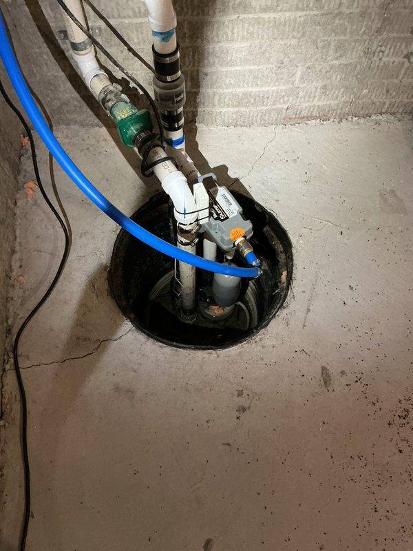 Responded to service call for sump pump system experiencing constant water dripping and excessive noise since January, along with water heater maintenance request. Upon inspection, evaluated sump pump basin installation with primary pump unit, float switch assembly, and backup water system. Identified potential issues related to elevated water table or system leak causing continuous water infiltration. Examined discharge piping, electrical connections, and float mechanism operation. Assessed black corrugated drainage pipes entering basin and verified pump cycling functionality. Performed diagnostic evaluation of water heater tank and completed flush procedure to remove sediment buildup and ensure optimal performance. Documented system configuration including PVC discharge lines, backup pump assembly, and electrical components. Provided recommendations for addressing constant water dripping issue and noise concerns.
