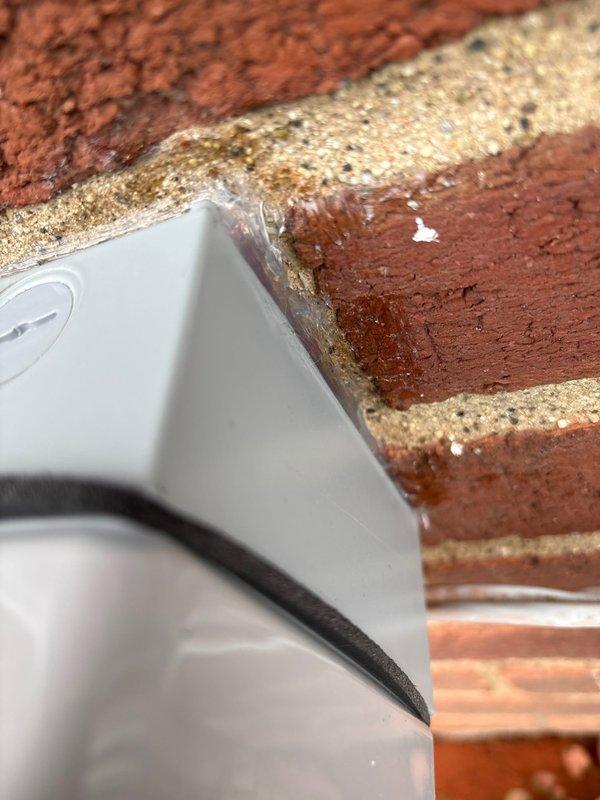 Installed weatherproof GFCI outlet on exterior brick wall to provide required electrical service within 25 feet of HVAC equipment, resolving city electrical code violation. Outlet features clear protective cover rated for outdoor use with proper sealing against moisture intrusion.