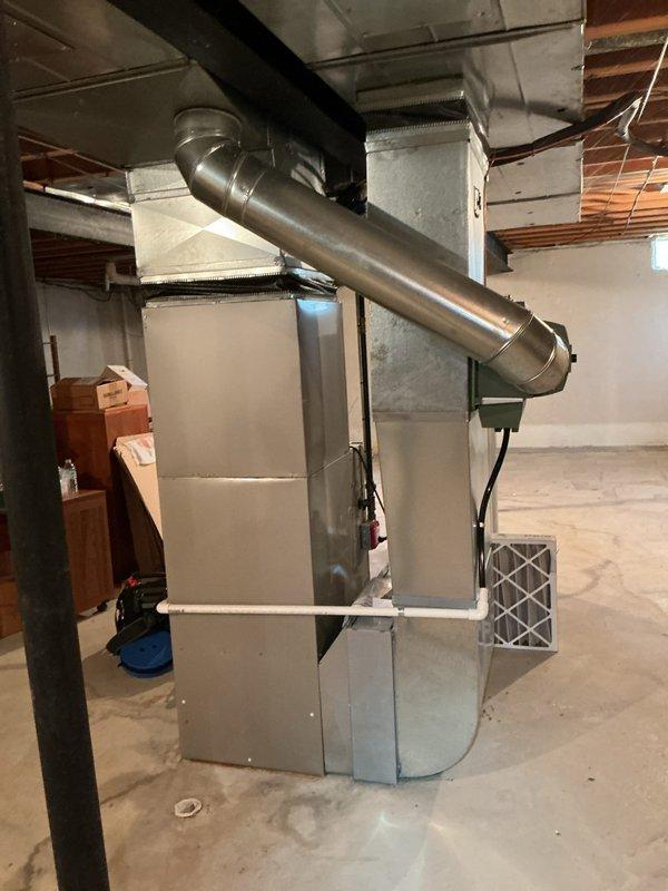 Completed comprehensive Gold AC inspection on 8-year-old residential HVAC system with air handler located in basement. Performed multi-point inspection including visual assessment of air handler unit, ductwork connections, condensate drainage system, and overall equipment condition. Verified proper operation of cooling system components, inspected metallic supply plenum and ductwork for integrity, examined PVC condensate lines for proper drainage, and assessed general accessibility and clearances around equipment. All components found to be functioning within normal parameters with no immediate service needs identified. System operational and ready for continued use.