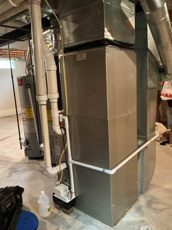 Completed comprehensive Gold AC inspection on 8-year-old residential HVAC system with air handler located in basement. Performed multi-point inspection including visual assessment of air handler unit, ductwork connections, condensate drainage system, and overall equipment condition. Verified proper operation of cooling system components, inspected metallic supply plenum and ductwork for integrity, examined PVC condensate lines for proper drainage, and assessed general accessibility and clearances around equipment. All components found to be functioning within normal parameters with no immediate service needs identified. System operational and ready for continued use.