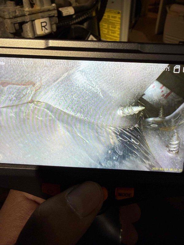 Responded to service call for 30-year-old furnace system in basement making loud motor noise that required customer to shut down unit. Upon inspection, discovered evaporator coil completely frozen with heavy ice buildup on copper tubing and coiled elements, indicating airflow restriction or refrigerant issue. Performed diagnostic evaluation of gray air handler and green furnace unit, identified failed blower motor as source of excessive noise and contributing factor to system freeze-up. Documented equipment condition with photos showing extensive frost accumulation and aging HVAC components. Recommended immediate blower motor replacement and full system evaluation due to advanced age of equipment and compromised operational safety.