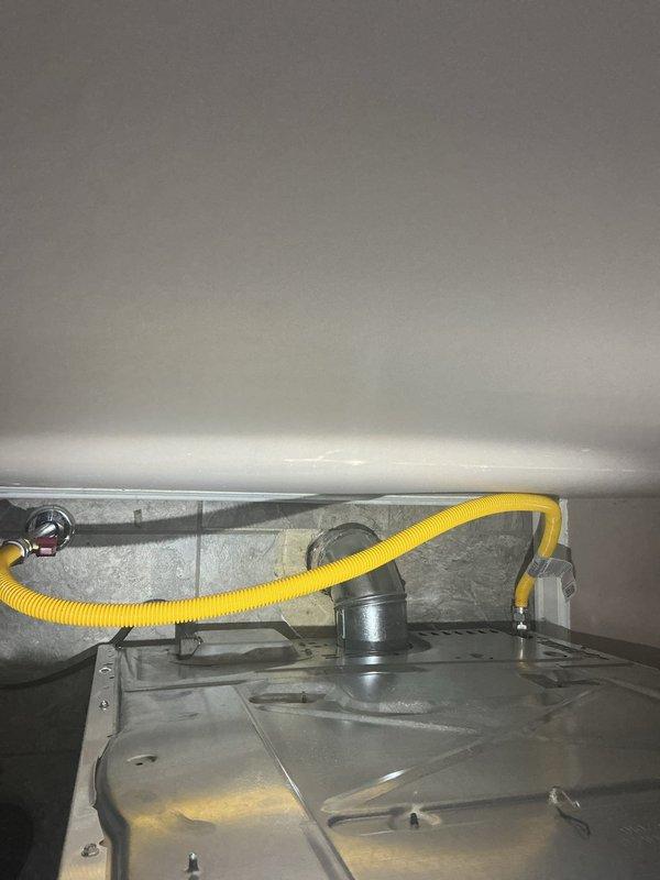 Completed gas line inspection and verification on water heater installation. Confirmed proper flexible gas connector installation with appropriate fittings and secure connections at both termination points. Verified gas valve assembly and burner compartment components are functioning correctly with no visible signs of leakage or deterioration. Inspected black iron gas piping run in basement area, confirming proper support and coupling integrity along horizontal run beneath floor joists. All gas connections tested and found to be secure with no safety concerns identified.