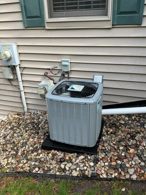 Completed comprehensive Gold AC inspection on 4-year-old single residential cooling system with air handler located in basement. Verified White Rodgers programmable thermostat operation at 74 degrees with proper temperature control functionality. Inspected outdoor condensing unit positioned on rubber pad with river rock landscaping, confirmed proper installation with copper refrigerant lines, insulated linesets, electrical disconnect, and adequate clearances for airflow and serviceability.
