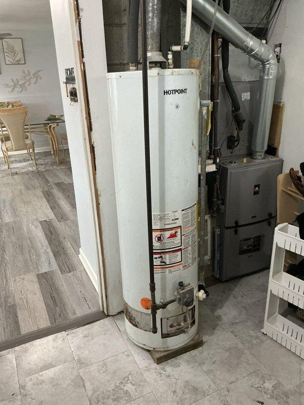 Responded to service call following home inspection report indicating concern with pipe fitting near shut-off valve on Hotpoint tanked water heater. Upon arrival, performed thorough visual inspection of water heater and associated plumbing connections in basement utility area. Examined copper piping, brass fittings, and valve assembly at top of unit where concern was identified. Assessed condition of all accessible pipe connections, including inlet and outlet fittings, pressure relief valve discharge pipe, and shut-off valve assembly. Noted visible corrosion staining on copper piping and general age-related wear on water heater unit. Documented existing conditions with photographs for homeowner records. Provided professional assessment of fitting integrity and recommendations for any necessary corrective action to ensure safe and code-compliant operation of domestic hot water system.