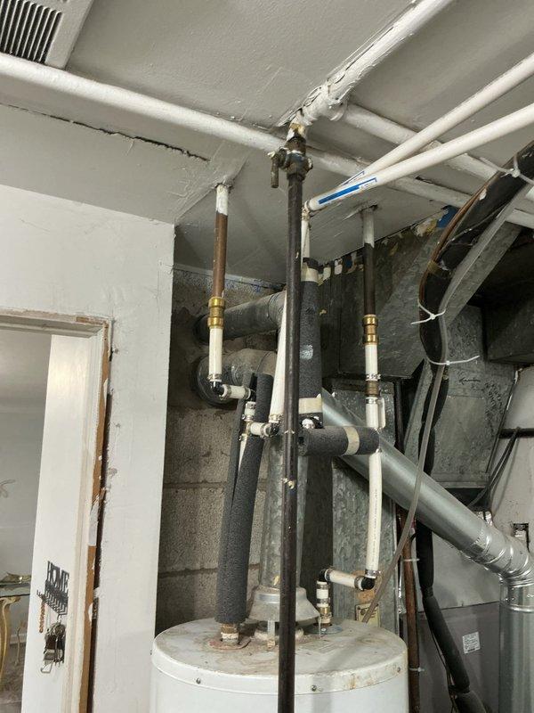 Responded to service call following home inspection report indicating concern with pipe fitting near shut-off valve on Hotpoint tanked water heater. Upon arrival, performed thorough visual inspection of water heater and associated plumbing connections in basement utility area. Examined copper piping, brass fittings, and valve assembly at top of unit where concern was identified. Assessed condition of all accessible pipe connections, including inlet and outlet fittings, pressure relief valve discharge pipe, and shut-off valve assembly. Noted visible corrosion staining on copper piping and general age-related wear on water heater unit. Documented existing conditions with photographs for homeowner records. Provided professional assessment of fitting integrity and recommendations for any necessary corrective action to ensure safe and code-compliant operation of domestic hot water system.