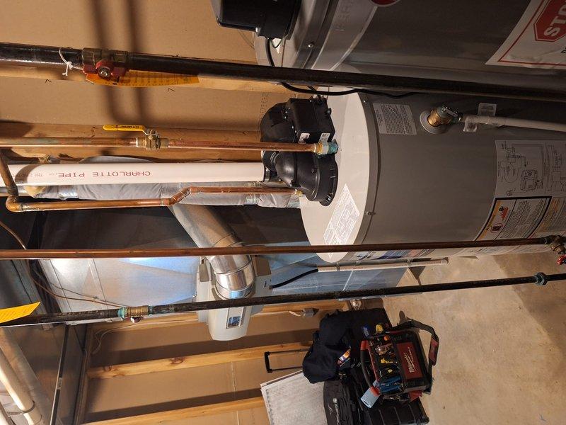Installed a 50-gallon standard tanked water heater in residential utility room with complete plumbing reconnection. Connected hot and cold water supply lines using copper piping, installed circulation pump assembly with electrical wiring, and secured all connections with appropriate shutoff valves. All plumbing connections were properly fitted with Charlotte Pipe PVC components where applicable, system was tested for proper operation, and installation meets mechanical code requirements.