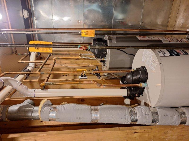 Installed a 50-gallon standard tanked water heater in residential utility room with complete plumbing reconnection. Connected hot and cold water supply lines using copper piping, installed circulation pump assembly with electrical wiring, and secured all connections with appropriate shutoff valves. All plumbing connections were properly fitted with Charlotte Pipe PVC components where applicable, system was tested for proper operation, and installation meets mechanical code requirements.