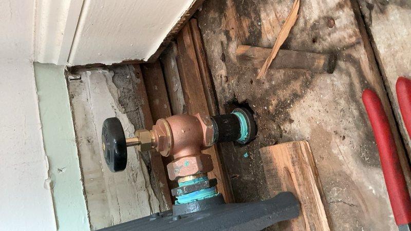 Ordered replacement hydronic radiator unit under PO 1302869-001 with 2-3 week lead time for delivery. Documented existing installation location showing exposed wall framing, copper plumbing connections with shutoff valve, and deteriorated wall conditions requiring radiator replacement. Customer will be contacted upon arrival of new unit for installation scheduling.