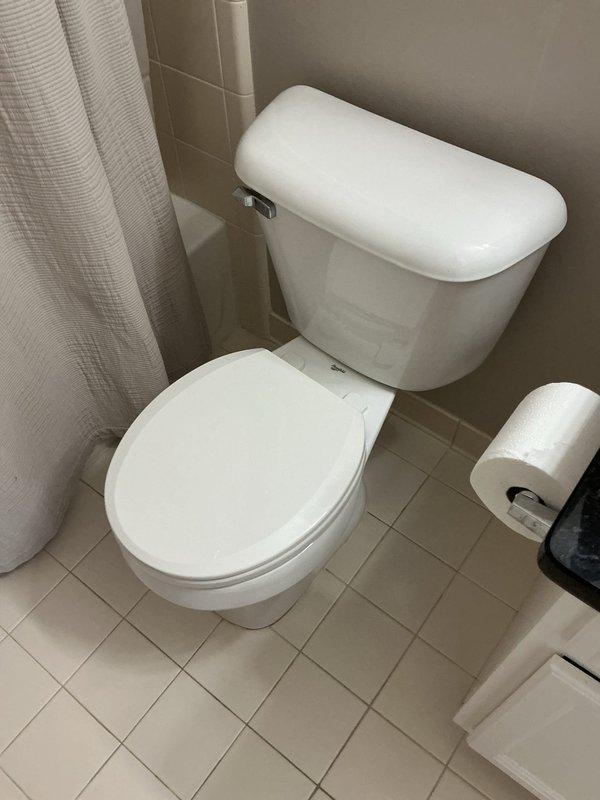 Responded to water leak complaint affecting first-floor condo unit originating from second-floor bathroom. Diagnosed leak source as failing toilet seal on upper level. Removed existing toilet, inspected flange and subfloor for water damage, and installed new toilet with wax ring seal to eliminate active leak and prevent further water intrusion to unit below.