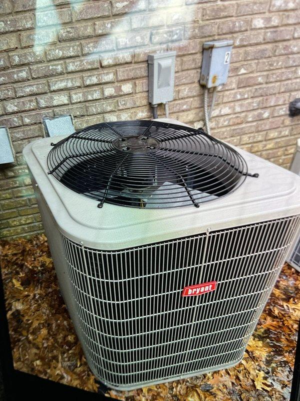Completed comprehensive Gold AC inspection on a 17-year-old Bryant two-unit residential cooling system with basement-located air handler. Performed full system evaluation including condenser unit examination, operational testing, and visual assessment of outdoor equipment condition. Noted significant leaf debris accumulation around condenser base and weathering on unit housing with visible rust spots on top panel. Documented equipment status with photographic evidence showing operational condenser with intact protective grilles and fan guard assembly. System confirmed operational at time of inspection with both units functioning as designed.