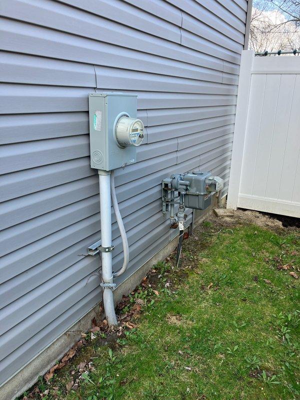 Conducted comprehensive on-site evaluation for complete HVAC system replacement including 2-ton furnace, air conditioning unit, and hot water heater. Inspected existing outdoor condenser unit mounted on concrete pad with vibration dampening base, assessed refrigerant line penetrations through exterior wall, and verified electrical disconnect box configuration. Documented current system specifications and photographed equipment condition for replacement estimate preparation. Evaluated utility service connections including electric and gas meter locations to determine installation requirements for new equipment. Provided customer with detailed replacement options and system specifications for complete system upgrade.