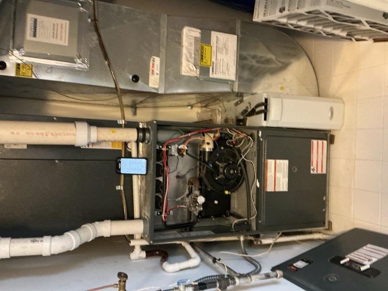 Completed comprehensive Gold AC Inspection on two outdoor air conditioning units. Performed full system evaluation including visual inspection of indoor furnace and air handler components, verified electrical connections and wiring harness integrity, checked blower motor operation, and inspected refrigerant lines and condensate drain system. Documented equipment condition with photographic evidence showing operational HVAC system with accessible internal components and corroded flexible ductwork requiring future attention.