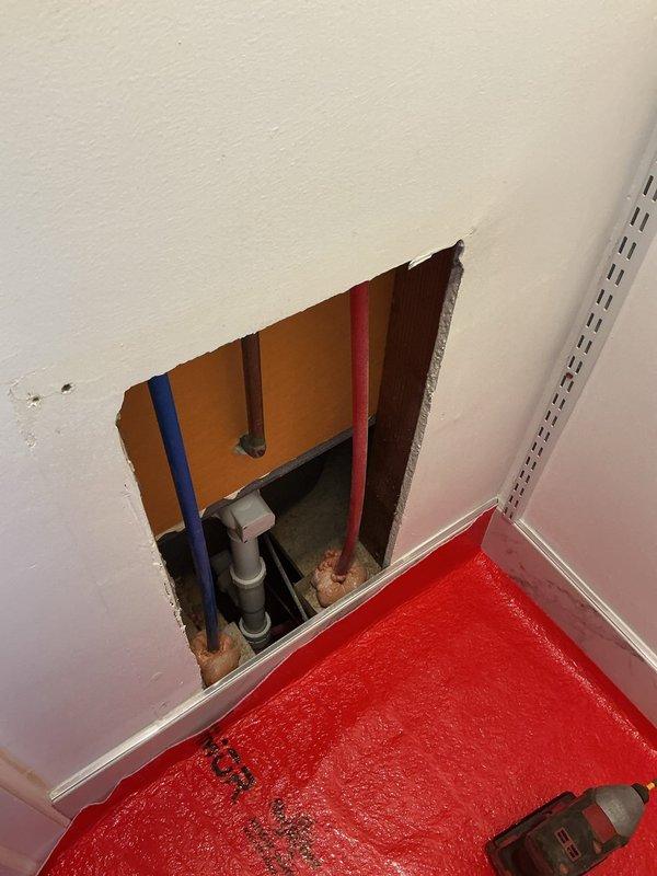 Responded to a plumbing leak that caused water damage in the bathroom. Cut access opening in adjacent room wall to expose and repair leaking supply lines behind the shower valve assembly. Deployed air movers and protective floor covering throughout affected bathroom area to facilitate drying and prevent secondary water damage to flooring and adjacent spaces.