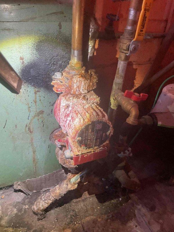 Responded to reported gas odor near boiler system. Conducted comprehensive safety inspection of aging boiler and associated gas lines. Upon investigation, identified severely corroded circulator pump assembly with extensive mineral buildup and water damage throughout mechanical components. Detected active moisture infiltration around pump base with visible pooling on concrete floor beneath equipment. Performed gas leak detection testing on all connections and supply lines—no active gas leaks detected at time of inspection. The reported gas odor was determined to be unrelated to actual gas leak. Conducted full operational assessment of boiler system, examining burner assembly, heat exchanger, venting system, and all safety controls. Documented extensive corrosion on pump housing and deteriorating copper piping connections. Advised customer that while no immediate gas leak exists, the severely corroded circulator pump and associated plumbing components require replacement due to advanced