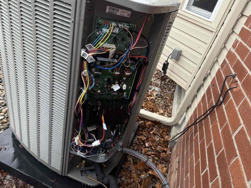 Performed AC system start-up on residential split system with basement evaporator coil and outdoor condensing unit. Accessed outdoor unit electrical compartment to verify proper connections and control board operation, noting frost accumulation on internal components indicating active refrigerant flow. Inspected basement evaporator coil installation including refrigerant lines, condensate drainage system, and electrical connections secured to floor joists. Noted requirement to return for vinyl tubing replacement on condensate pump system pending availability of additional materials from shop.