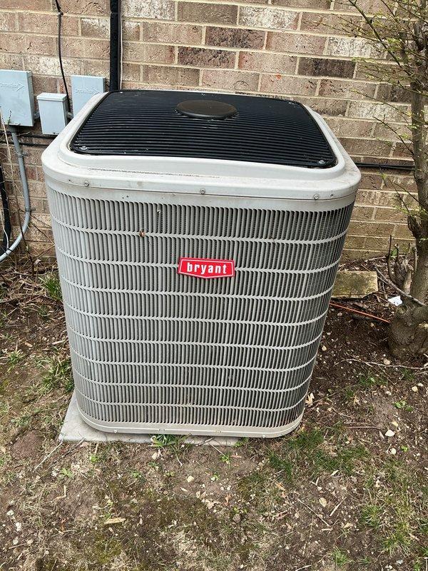 Completed Gold plan cooling maintenance on a 2-year-old Bryant air conditioning system with outdoor condenser unit installed on concrete pad against exterior wall. Performed comprehensive AC tune-up including inspection of condenser coils, refrigerant lines, electrical connections, and overall system operation. Unit found in good working condition with no issues identified; all components functioning properly and system ready for cooling season.