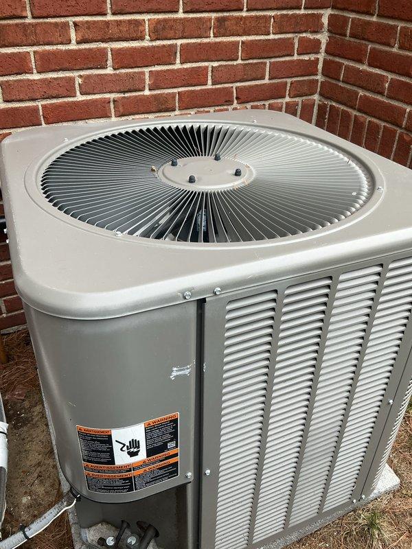 Completed routine Gold AC maintenance inspection on outdoor condenser unit located against exterior brick wall. Performed comprehensive tune-up including cleaning condenser coils, checking refrigerant levels, testing electrical connections and capacitor, inspecting fan motor operation, verifying proper airflow through louvered panels, and ensuring all safety controls functioning correctly. Unit operating within normal parameters with no issues identified; system ready for cooling season.