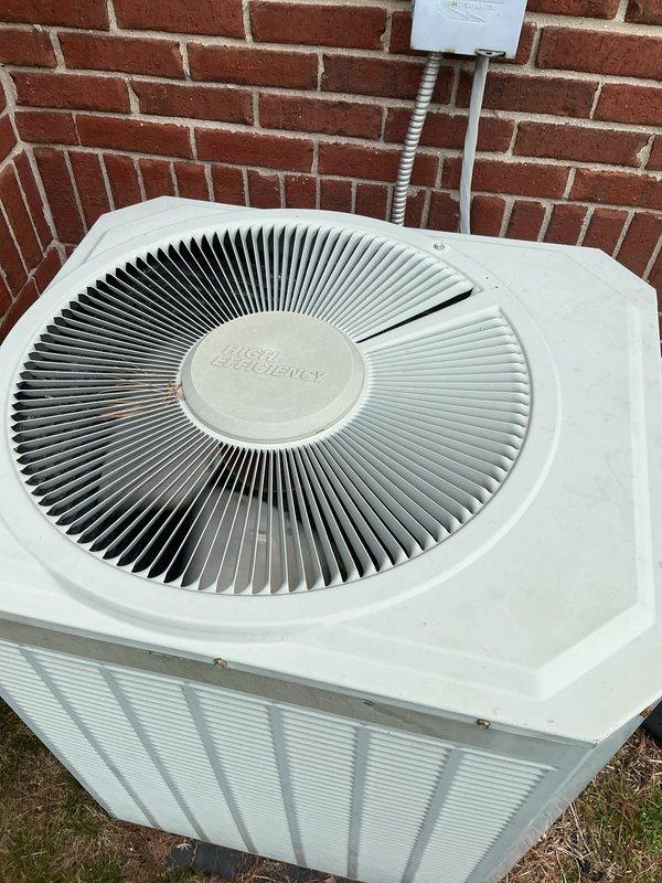 Completed routine Gold AC maintenance inspection on outdoor condenser unit located against exterior brick wall. Performed comprehensive tune-up including cleaning condenser coils, checking refrigerant levels, testing electrical connections and capacitor, inspecting fan motor operation, verifying proper airflow through louvered panels, and ensuring all safety controls functioning correctly. Unit operating within normal parameters with no issues identified; system ready for cooling season.