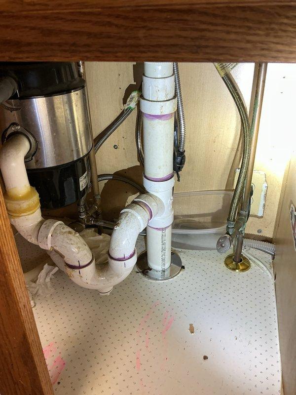 Responded to a leaking kitchen faucet in a residential property. Upon inspection, identified the source of the leak at the faucet assembly with pull-down spray head feature. Accessed the under-sink plumbing area and inspected all connections, supply lines, and the P-trap configuration. Tightened loose fittings on the braided metal supply lines and verified proper seating of the faucet mounting hardware. Tested the faucet operation including spray head function and checked for any residual leaks. All connections secured and leak resolved with no further dripping observed.