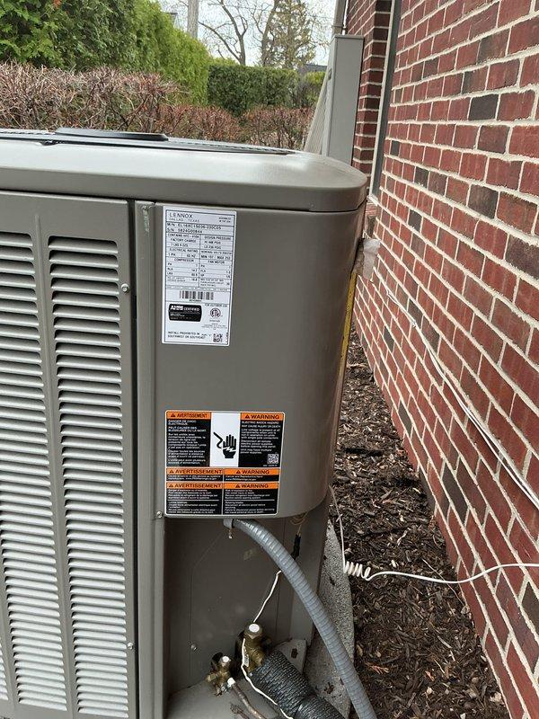 Completed comprehensive Gold AC Inspection on dual-unit residential HVAC system consisting of one 1-year-old and one 10-year-old Lennox outdoor condensing units with air handler located in basement. Performed full multi-point inspection including visual examination of both exterior units, verified proper fan operation with protective wire guards intact, checked refrigerant line connections and brass fittings for leaks, inspected electrical conduit and connections, confirmed units mounted securely on concrete pads with adequate clearance from structure, and documented equipment condition through photographic records. Both systems operational at time of inspection with no immediate service concerns identified.