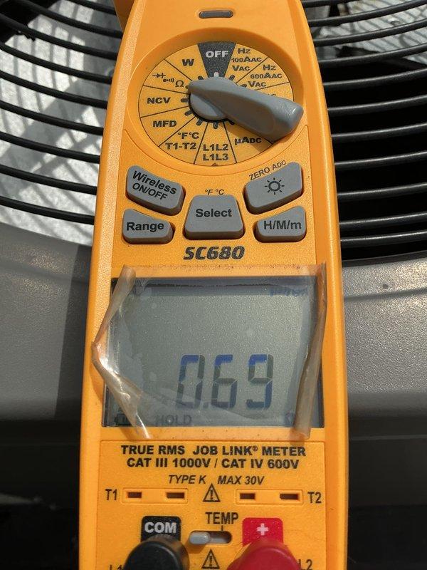 # HVAC Service Call - No Cool Condition

Responded to service call for 10-year-old air conditioning system with complete failure to operate. Upon arrival, located outdoor condenser unit positioned on gravel pad in backyard against exterior wall of residence.

## Diagnostic Procedures

Performed visual inspection of condenser unit exterior. Unit showed normal wear consistent with age, with no obvious physical damage to cabinet, fan grille, or mounting pad. Checked electrical supply at disconnect and verified power availability to equipment.

Utilized digital multimeter to test electrical components and measure voltage readings at various test points. Display reading of 069 captured during diagnostic testing indicated specific voltage or resistance measurement taken during troubleshooting process. Conducted systematic electrical diagnostics to isolate failure point in system.

## Findings

Determined root cause of no-cool condition through electrical testing protocols. System age of 10 y