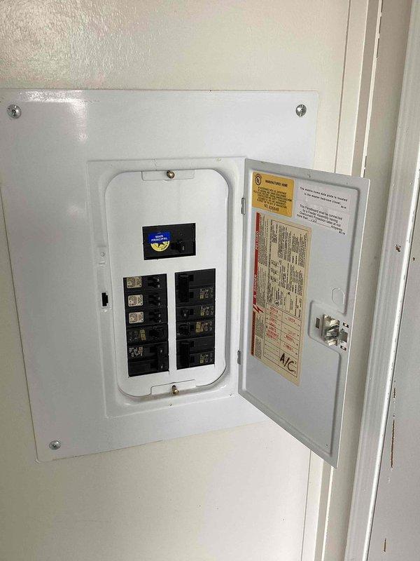Completed diagnostic evaluation and provided replacement estimate for aging R22 air conditioning system experiencing inadequate airflow and insufficient cooling capacity. Assessed existing unit located in interior utility closet near bathroom, documented electrical panel configuration and current HVAC installation within louvered cabinet enclosure. Recommended full system replacement due to obsolete refrigerant type and equipment age affecting performance.