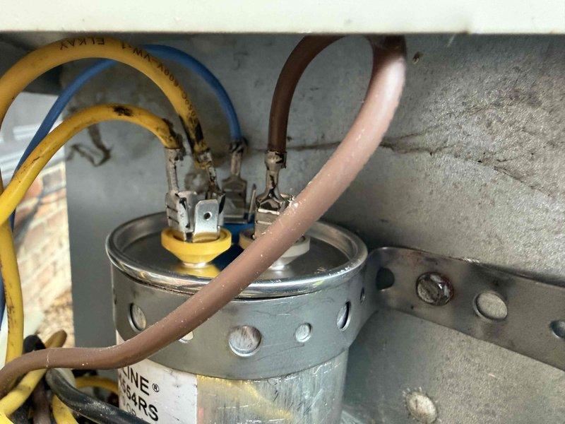 Responded to service call for central air conditioning system experiencing reduced cooling efficiency. Upon inspection, identified failed dual-run capacitor showing visible signs of deterioration, oxidation, and discoloration. Replaced defective capacitor with new unit, reconnected all electrical terminals per manufacturer specifications, and verified proper system operation. Unit now cooling effectively with normal compressor and fan motor operation restored.