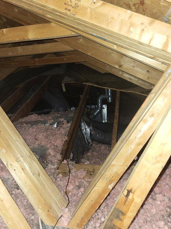 Provided estimate for replacement of 24-year-old second-floor air conditioning system with failed outdoor fan motor and cracked/broken condenser top where motor mounts. Evaporator coil located in attic with extremely tight access constraints documented through photos showing limited workspace and existing ductwork configuration. Property contains two AC units total; assessed second unit with seized fan motor and confirmed operational status of remaining system components per customer request.