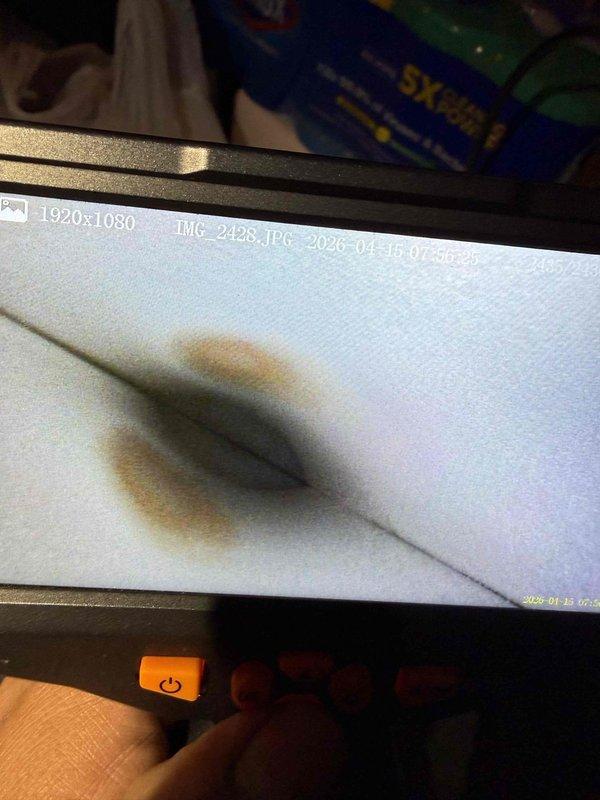 Completed comprehensive Gold AC inspection on 25-year-old residential air conditioning system with air handler located in basement. Performed temperature diagnostics on outdoor condenser unit, recording operating temperatures using digital thermometer. Inspected evaporator coil and identified visible staining on coil surface indicating potential condensate or moisture-related issues. System currently operational with all components functioning at time of inspection.