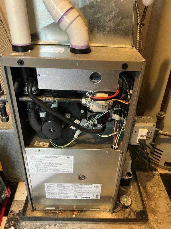 Completed comprehensive Gold furnace inspection on a 1-year-old forced air heating system located in the basement. Unit was operational at time of service. Removed front access panel and thoroughly inspected all internal components including blower motor assembly, electrical connections, control board, gas lines, and mechanical systems. Verified proper installation and condition of PVC venting pipes with 90-degree bends. Examined air filter condition, electrical connections including multi-colored wiring harnesses, and verified all manufacturer labels and specifications were intact. All components showed normal wear consistent with one year of operation, with typical dust accumulation noted. System found to be operating within manufacturer specifications with no immediate safety concerns or required repairs identified.