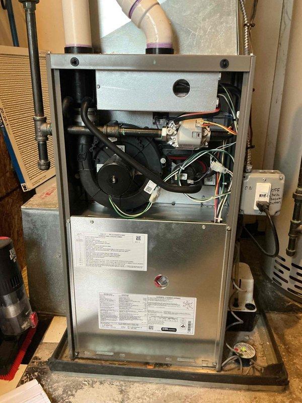 Completed comprehensive Gold furnace inspection on a 1-year-old forced air heating system located in the basement. Unit was operational at time of service. Removed front access panel and thoroughly inspected all internal components including blower motor assembly, electrical connections, control board, gas lines, and mechanical systems. Verified proper installation and condition of PVC venting pipes with 90-degree bends. Examined air filter condition, electrical connections including multi-colored wiring harnesses, and verified all manufacturer labels and specifications were intact. All components showed normal wear consistent with one year of operation, with typical dust accumulation noted. System found to be operating within manufacturer specifications with no immediate safety concerns or required repairs identified.