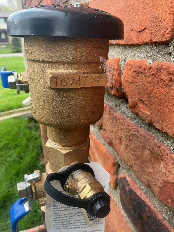 Completed annual testing and certification of PVB (Pressure Vacuum Breaker) backflow preventer assembly mounted on exterior brick wall. Inspected backflow device with identification tag T694119, verified proper operation of vacuum breaker mechanism and brass valve assembly, confirmed all components functioning within specifications. Documented installation with photographs showing complete assembly including Zurn ball valves, copper piping configuration, and proper mounting to building exterior for compliance records.