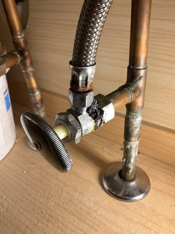 Responded to recurring issue where toilet flushing caused bathtub to gurgle in first-floor bathroom of 70-year-old home. Inspected plumbing system and identified venting problem consistent with previous service call. Replaced corroded shut-off valve and associated hardware showing significant oxidation and wear, installed new braided stainless steel supply line, and verified proper drainage and venting to eliminate gurgling condition.