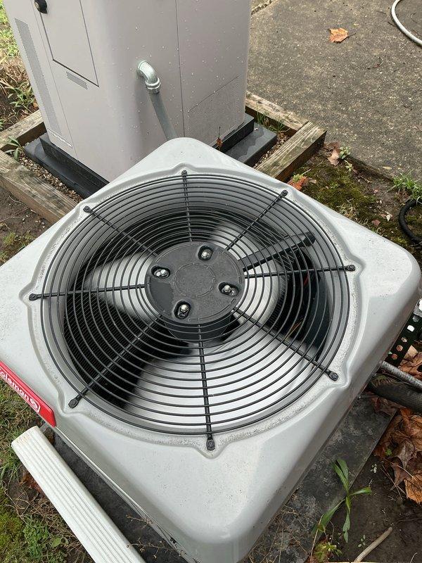 Completed comprehensive Gold Plan AC inspection on 6-year-old residential air conditioning system with basement-located air handler. Performed full system evaluation of outdoor condenser unit, which was found to be operational and in satisfactory condition. Verified proper fan operation, inspected electrical connections at disconnect panel, and confirmed condenser unit was properly mounted on wooden platform with adequate clearance. Documented equipment condition through photographic records showing condenser fan assembly, housing integrity, and surrounding installation area. System confirmed to be functioning properly at time of inspection with no immediate service needs identified.