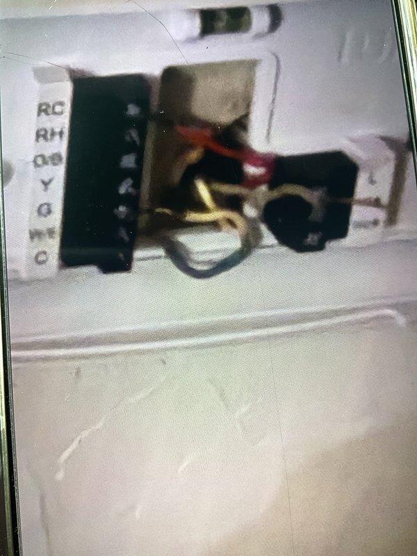 Responded to no cooling complaint on 3-year-old AC system with history of multiple service issues. Inspected thermostat wiring at wall terminal to verify proper connections and diagnose potential wiring concerns from previous service. Examined RC, RH, Y, G, W/E, and C terminal connections, documented existing wire configuration with multiple conductors terminated at terminal blocks. Discussed options with customer for installing dedicated common wire to improve thermostat power supply and system reliability.
