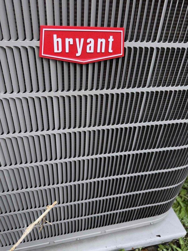 Completed comprehensive Gold AC inspection on 10+ year old Bryant air conditioning system with air handler located in basement. Performed full system evaluation including outdoor condenser unit examination, verified proper equipment operation, and documented unit condition through photographic records. System found to be functioning properly at time of inspection with condenser unit showing normal weathering consistent with age, protective grilles intact, and all components operational.