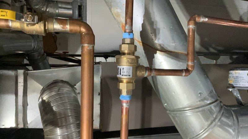 Completed installation of radiator air vent and key valve on hydronic heating system piping. Installed brass automatic air vent fitting with shut-off capability on copper supply line to eliminate trapped air and improve system efficiency. Verified proper operation of all connections and confirmed no leaks at installation points.