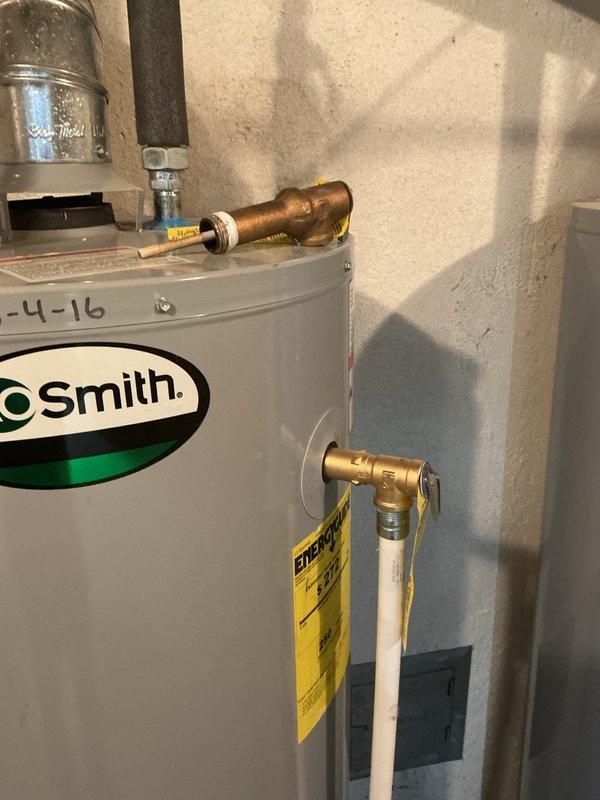 Replaced defective temperature and pressure relief (TPR) valve on A.O. Smith tanked water heater located in basement utility room. Inspected existing copper and PVC plumbing connections, verified proper installation of new brass TPR valve with discharge pipe routing to floor level per code requirements. Tested valve operation, checked for leaks at all connections, and confirmed water heater returned to normal operating parameters with no additional issues identified.