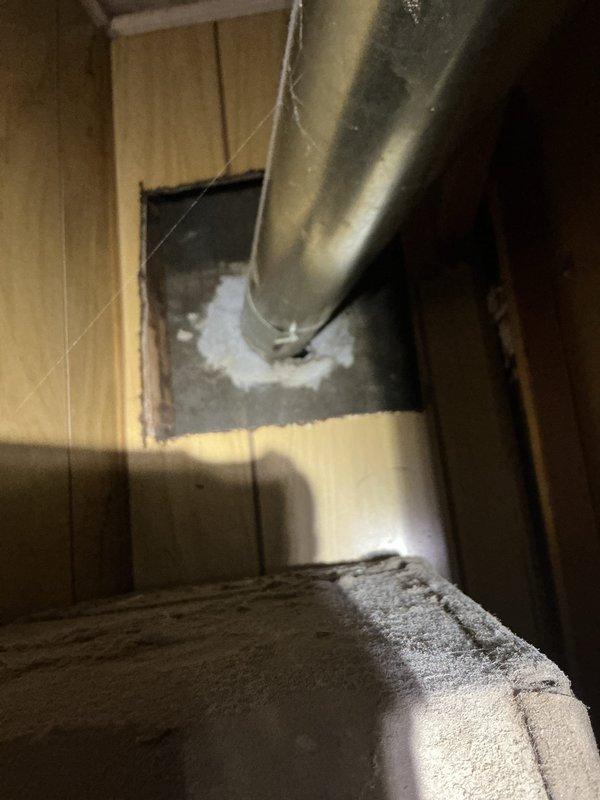 Completed comprehensive tune-up and city certification inspection on gas furnace at vacant property with representative present. System exhibited significant corrosion on heat exchanger and burner assembly; documented conditions with photos showing rust deterioration on combustion chamber, confirmed proper operation of gas valve, igniter control module, and burner assembly. Verified ductwork installation and insulation integrity in utility space, confirmed adequate sealing at wall penetrations with spray foam insulation.
