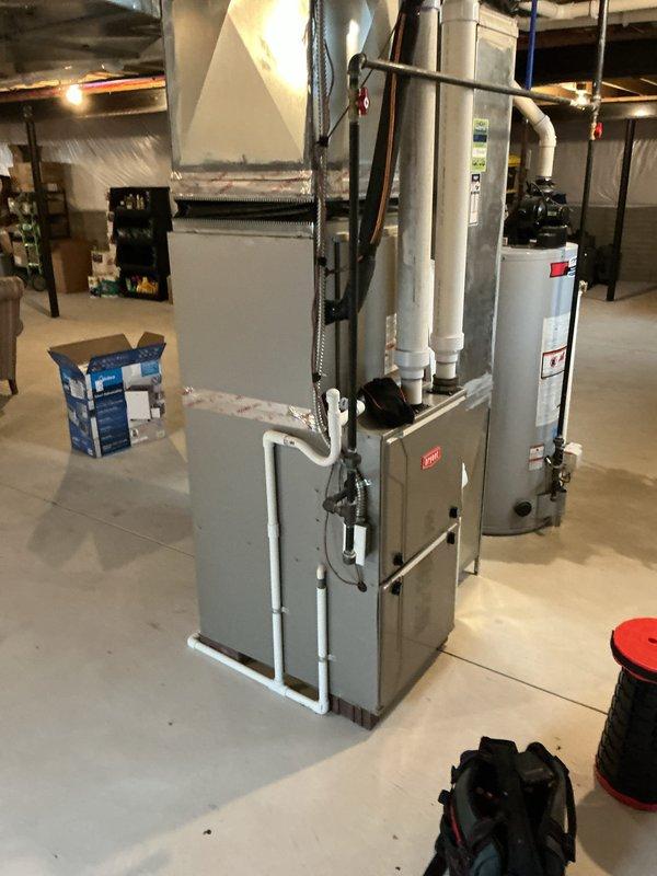 Completed comprehensive Gold AC inspection on 5-year-old Bryant HVAC system with basement-located air handler. Performed full system evaluation including visual inspection of furnace, evaporator coil, condensate drainage system, ductwork connections, and all associated mechanical components. Verified proper operation of heating and cooling equipment, inspected PVC venting and drainage lines, examined gas line connections, assessed humidifier attachment, confirmed adequate clearances around equipment, and documented system condition through photographic records showing all major components in satisfactory working order.