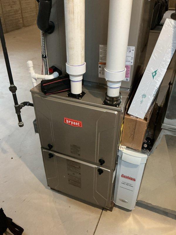 Completed comprehensive Gold AC inspection on 5-year-old Bryant HVAC system with basement-located air handler. Performed full system evaluation including visual inspection of furnace, evaporator coil, condensate drainage system, ductwork connections, and all associated mechanical components. Verified proper operation of heating and cooling equipment, inspected PVC venting and drainage lines, examined gas line connections, assessed humidifier attachment, confirmed adequate clearances around equipment, and documented system condition through photographic records showing all major components in satisfactory working order.